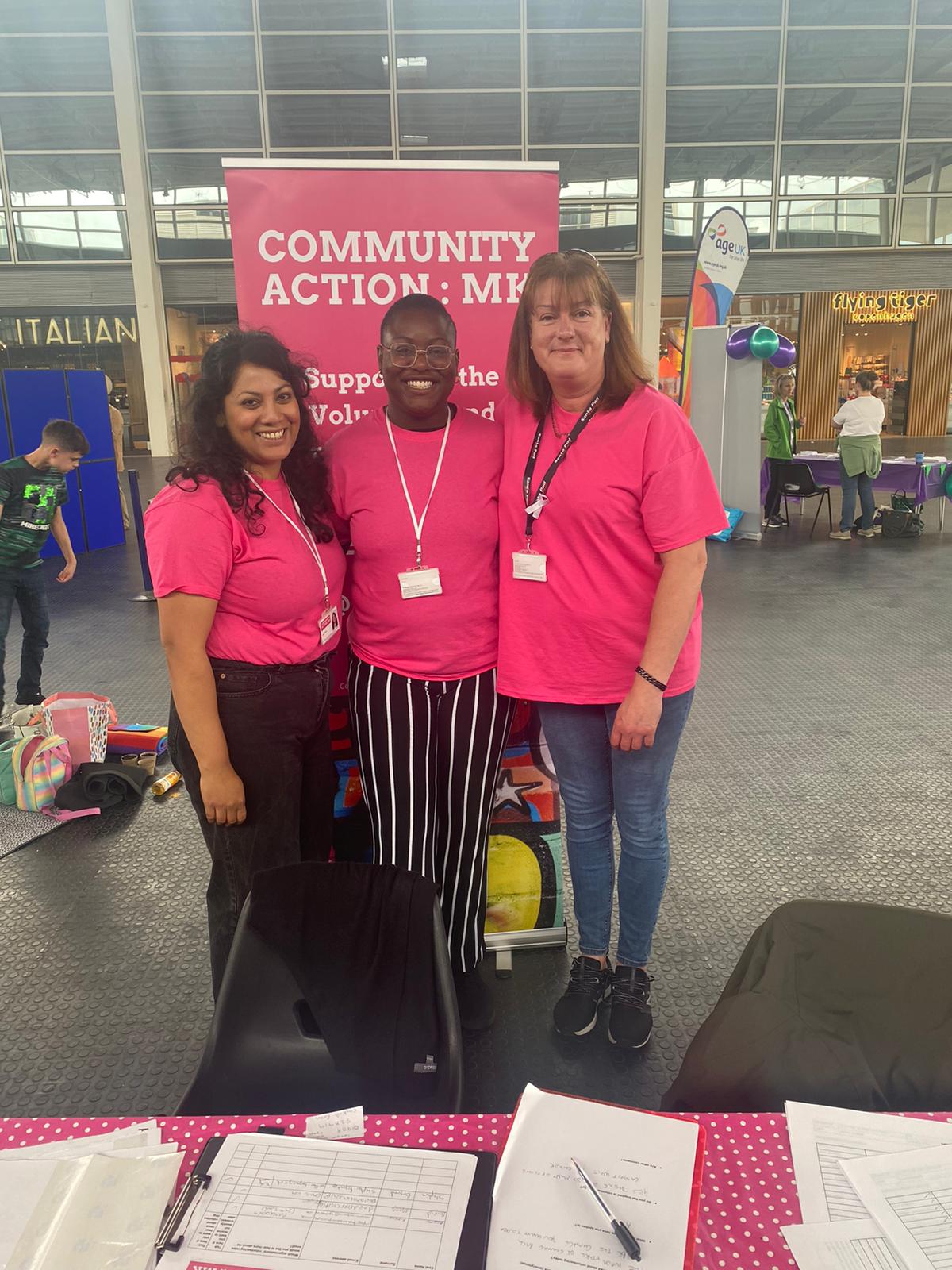 Three volunteers wearing pink T shirts