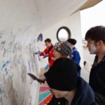 Young adults removing graffitti