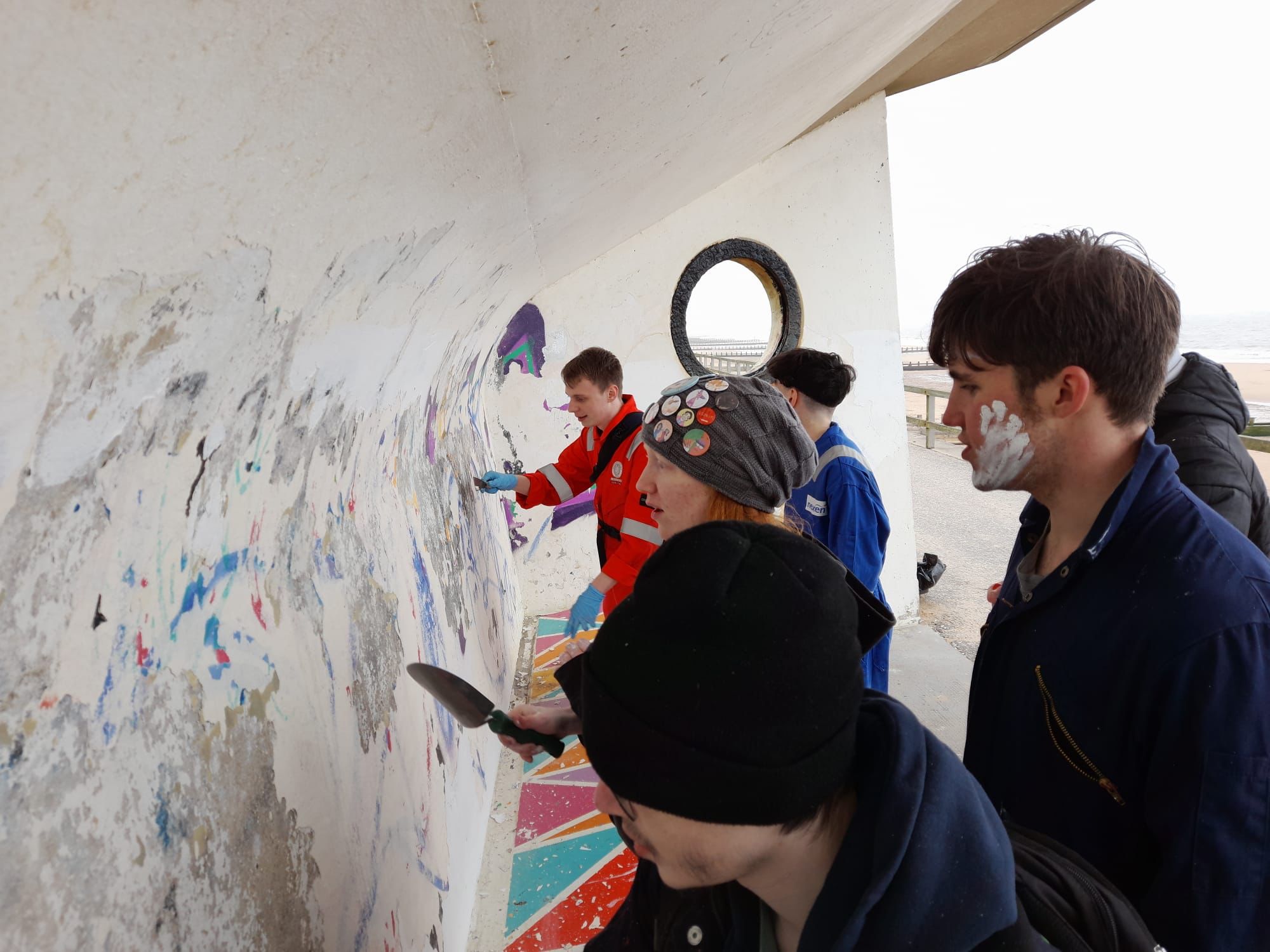 Young adults removing graffitti